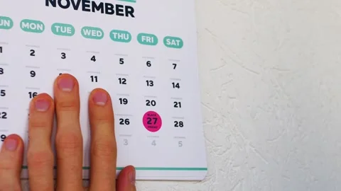 A man pointing finger to the marked Black Friday date on the November 2026 page Stock Footage 346703343