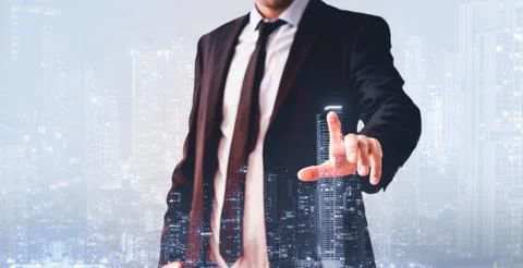 Man pointing finger at virtual screen,with modern city skyline - real estate  Foto stock