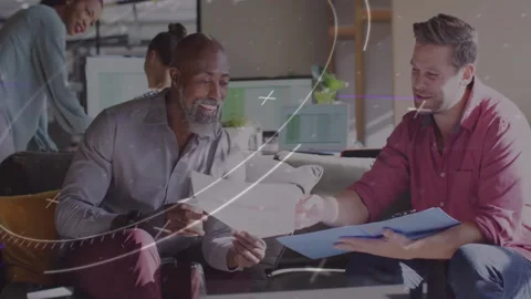 Man pointing folder and colleague leaning to review papers in business lounge Stock Footage 314408741