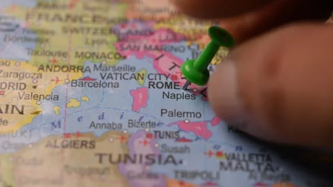 Man Pointing Green Pin on Rome Italy Location on Paper World Map Stock Footage 333553361