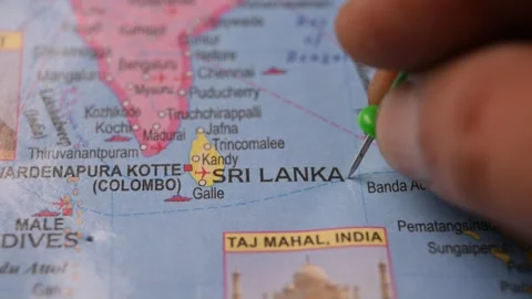 Man Pointing Green Pin on Sri Lanka Location in Paper World Map Stock Footage 333552939