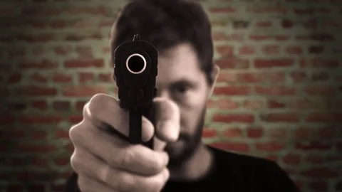 Man Pointing Gun At Camera On A Brick Wa... | Stock Video | Pond5