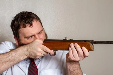 Man pointing a gun while at work Stock Photos