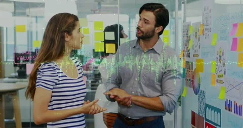 Man pointing planning wall causing animated chart highlight while woman touching Stock Footage 331006150