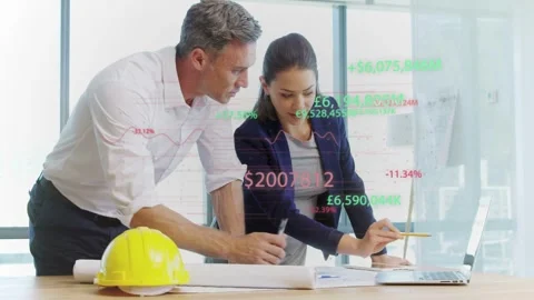 Man pointing at plans, woman annotating in design review, laptop graphs Stock Footage 333155431