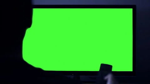 A Man Pointing Remote Control on Smart TV Green Screen at Night. 4K. Video stock 271155278