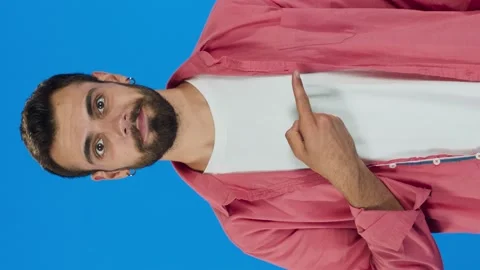 Man pointing to the right of the screen with her fingers on a blue background. Stock Footage 143916837