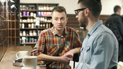 Man pointing on something in the cafe and talking with his friend, steadycam  Stock Footage 73442503