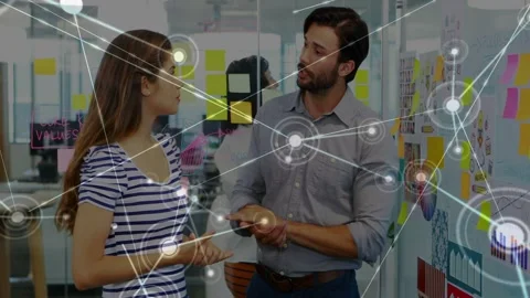 Man pointing sparking node map marking sticky notes on glass while woman Stock Footage 333526084