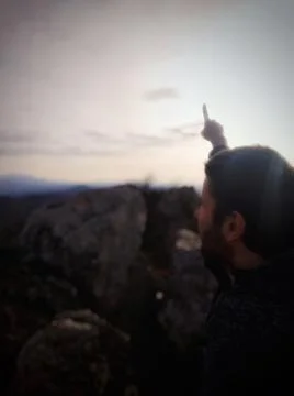 Man Pointing Toward the Sky from a Mountain 스톡 사진