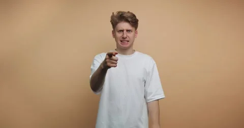 Man points and gestures towards the camera in a session in a studio with a .. 動画素材 328247119