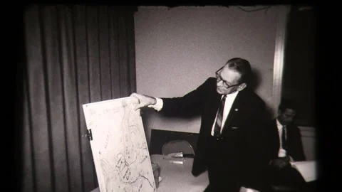 Man Points at Chart American Life, Small Town Meeting at Local Community Center  Stock Footage 130355050