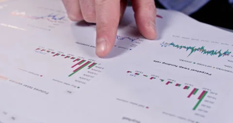 Man points to chart on paper document and places glasses down Stockbeeldmateriaal 304488746