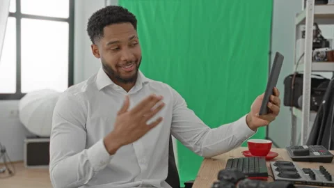 Man points finger at tablet while smiling and holding it beside keyboard an.. Stock Footage 347866559