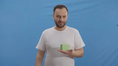 The man points to the green little box and looks at the screen and laughs. Stock Footage 148578929