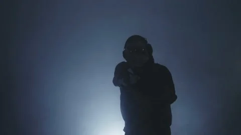 The man points the gun at the camera Blue background. Video stock 229314929