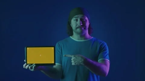 A man points his index finger at the green screen of a tablet and shows a thumbs Stock Footage 252016873