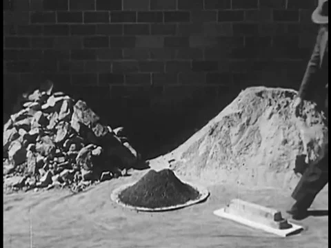 A man points to a lead pig, lead concentrate and lead ore and examples of the Stock Footage 74968091