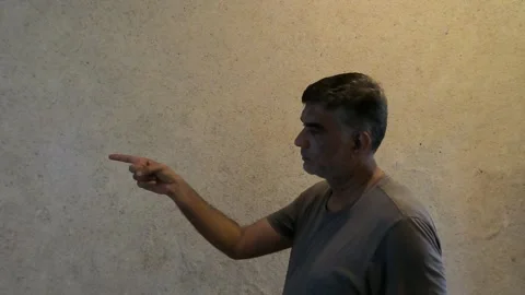 Man Points With One Hand Indoors Showing Something in Side Profile Stock Footage 313279783