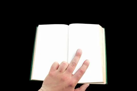 Man points to an open book on an isolated black background Stock Photos