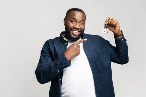 The man points at a set of keys he's holding, creating a perfect setting for Foto stock