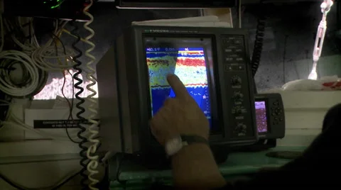 A man points to a sonar display on a small vessel. Stock Footage 46556315