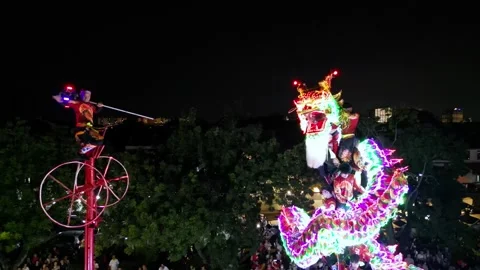 A man is on a pole with a dragon dance perform from Thailand 스톡 동영상 318099586