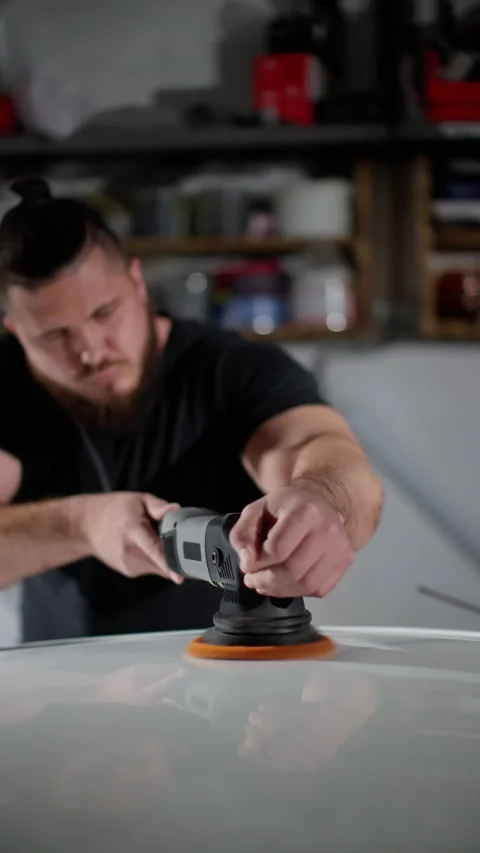 A man is polishing a car with a buffing tool Stock Footage 269908511