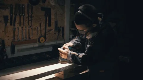 Man polishing solid wood, joiner labouring in mask for safety, solid wood furnit Video stock 78709662