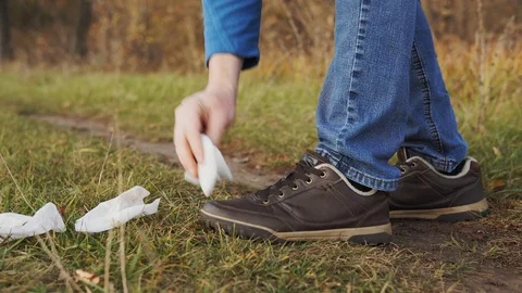 Man pollution nature concept. A close-up shot of an irresponsible man in jeans Stock Footage 120872636