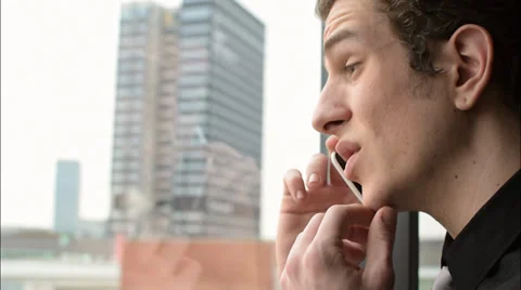 Man pondering while speaking on phone Vidéo 36270842