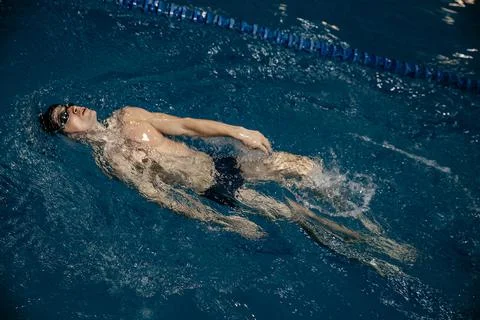 Man in the pool. Floating on his back. A swimmer trains in the pool on the track Foto stock