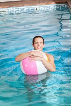 Man in the pool with inflatable ball Stock Photos