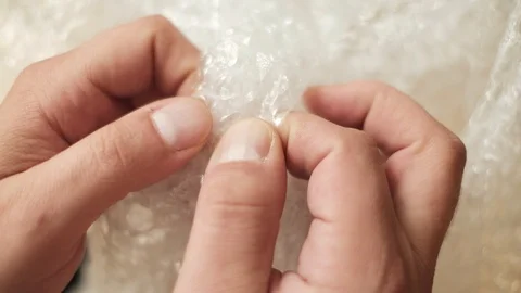 Man pops plastic bubble wrap Stock Footage 94902751