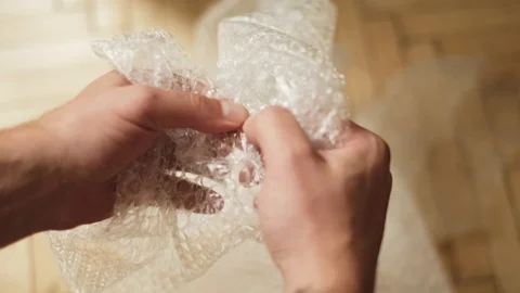 Man pops plastic bubble wrap Stock Footage 94903331