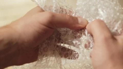 Man pops plastic bubble wrap Stock Footage 94903428