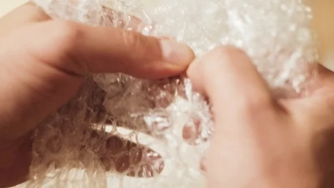 Man pops plastic bubble wrap Stock Footage 94904299