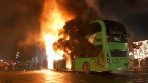Man poses with burning Dublin bus during 2023 riot Stock Footage 346246669