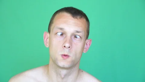 Man poses his face to camera, on green background. funny look, eyes  to nose. Stock Footage 109301319