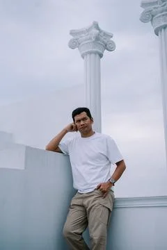 Man Posing Against Classical Architecture, thoughtful expression 库存照片