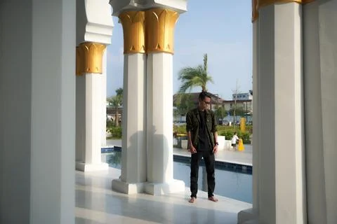 A man posing between the pillars of the beautiful mosque, at the Great Mosq.. Stock Photos