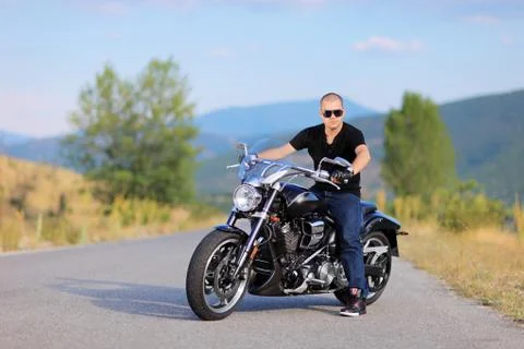 Man posing on a custom made motorcycle Stock Photos
