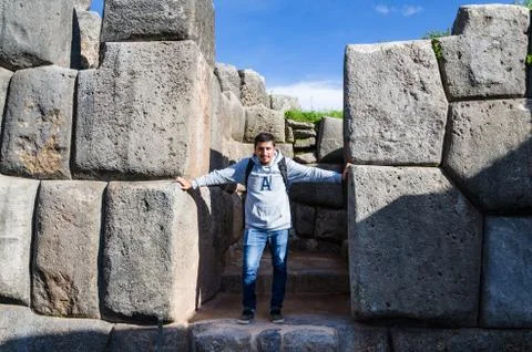 Man posing in front of the huge rocks of Sacsayhuaman in Cusco - Peru Stock Photos