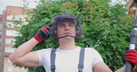 Man posing at garden with electric trimming machine in hands Stock Footage 263145897