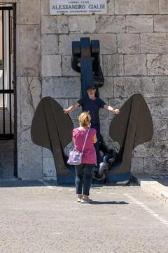 Man posing at large anchor while being photographed outside 库存照片