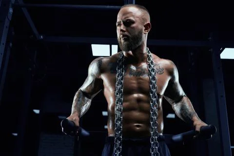 Man posing on parallel bars in gym. Stock-Fotos