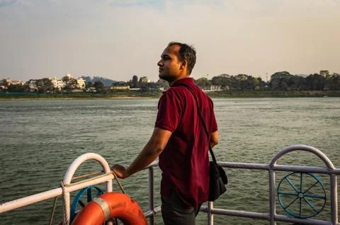 Man posing at ship deck with river horizon at evening Stock Photos