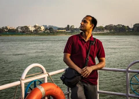 Man posing at ship deck with river horizon at evening 写真素材