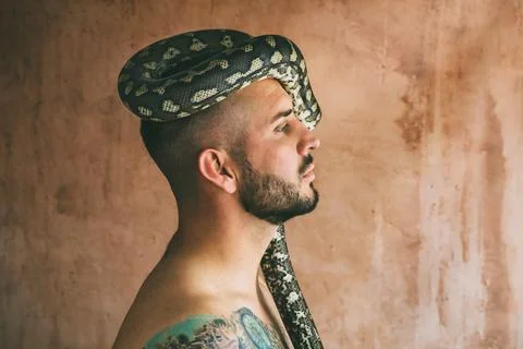 Man posing with snake on his head Stock Photos