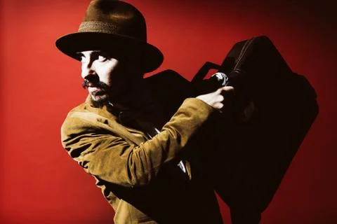 Man posing in studio with suitcase in hands Stock Photos